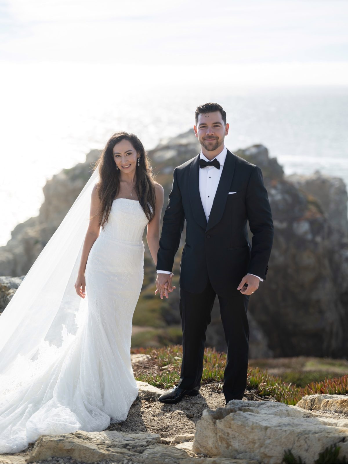 Ruben and Janeza facing the camera on the coast on their wedding day